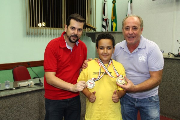 Jovem karateca posa com medalhas com vereador Ivan